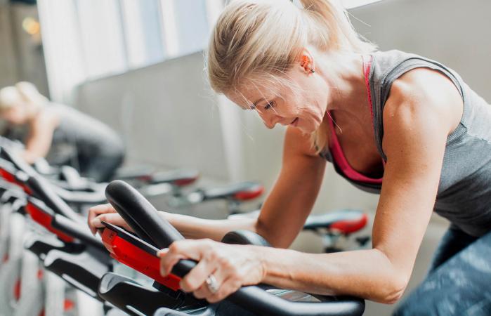 Woman exercising on stationary bicycle
