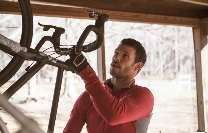 Athlete with bicycle in garage