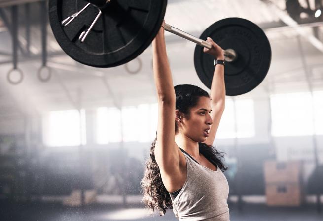 Woman lifting a barbell in a gym