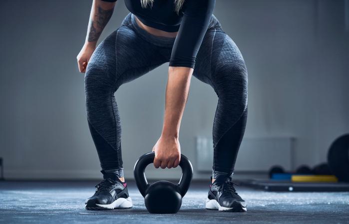 woman exercising with kettlebell at gym