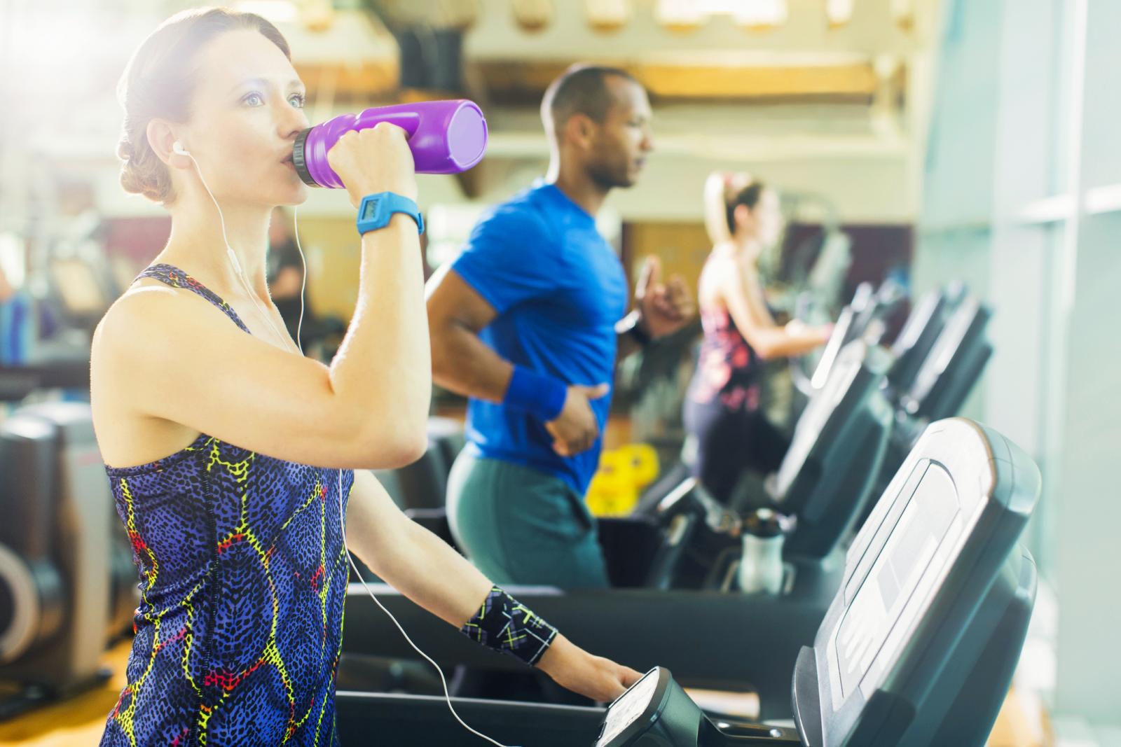 Woman on treadmill drinking water