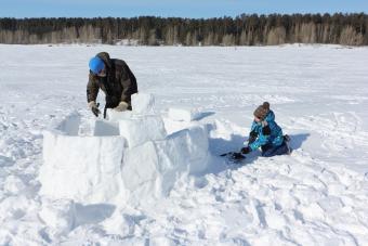 Man and boy building igloo