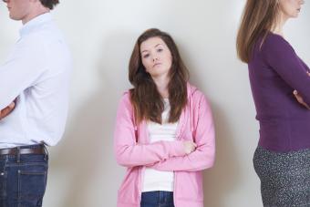 Young adult standing between parents with their backs to her