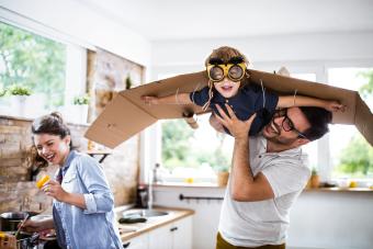 Happy boy pretending to be an airplane while his father is holding him in the air