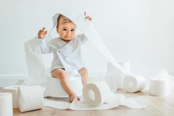 Cute baby girl with toilet paper rolls