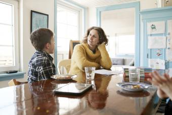 Mother and son eating and talking at dining table