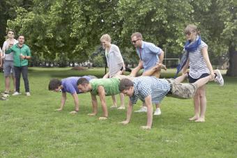 A group of friends playing wheel barrow race