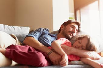 Father and son sleeping on sofa