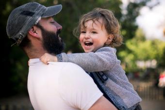 toddler boy and father laughing