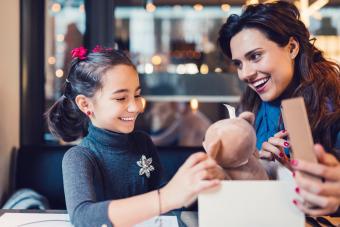 Girl in restaurant receiving a birthday gift from her mother