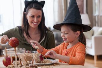 parent and child making caramel apples for Halloween