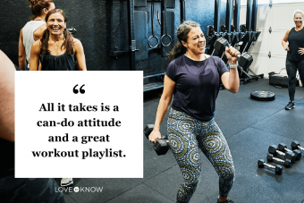 Smiling woman singing with dumbbell during fitness class with friends