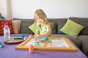 Woman playing Parcheesi boardgame