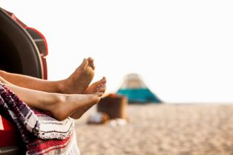 Couple relaxing inside vehicle on beach 