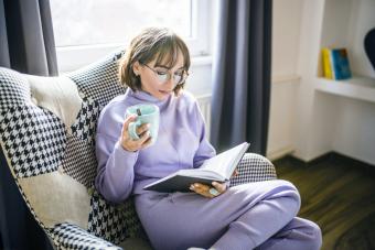 Woman relaxing with book and coffee at home