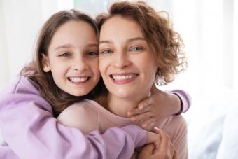 Affectionate teen girl hugging her mother