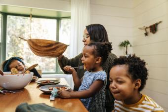 Mother passing salad bowl during family meal 