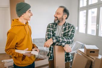 Boy and father talking while renovating apartment