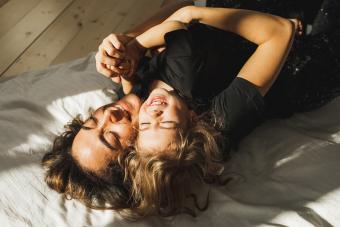 Beautiful mother and daughter having fun in bed