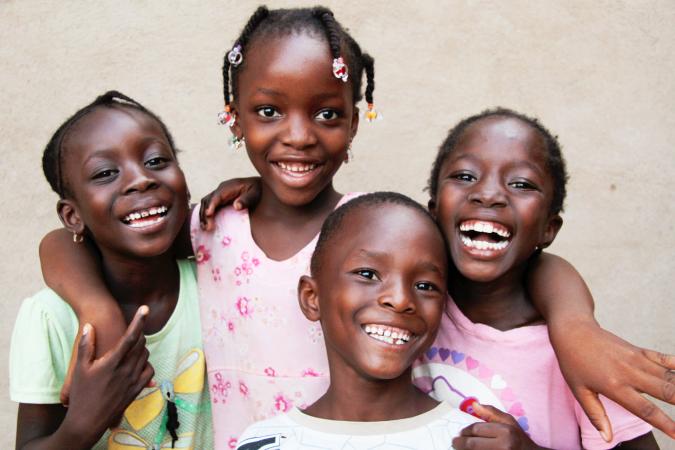 Several children smiling and hugging