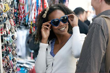Woman trying on sunglasses with friend