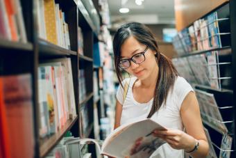 young lady reading book in bookstore