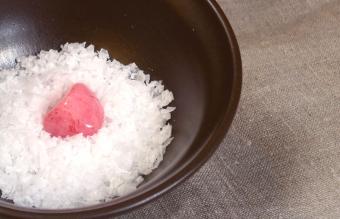 Cleansing rose quartz in bowl of salt