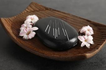 Acupuncture needles on a spa stone