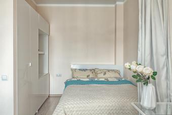 Small beige bedroom with bed and wardrobe