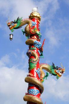 Chinese dragons coil up a pole.