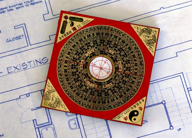 feng shui compass sitting on blueprints