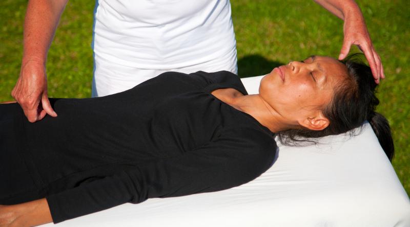 Woman receiving polarity therapy from a practitioner