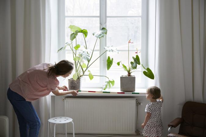 woman and child measuring a window