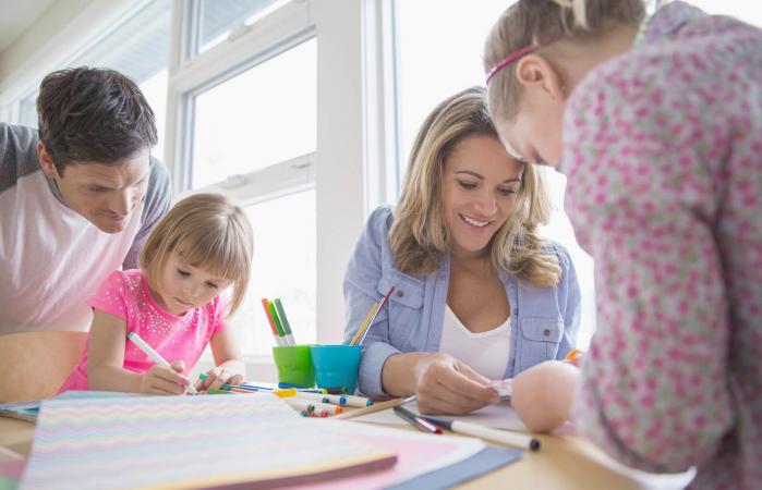 Family making paper crafts at table