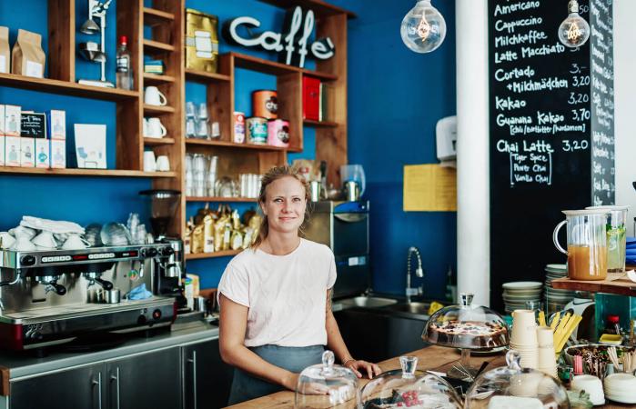 Waitress Standing At Her Coffee Shop Counter