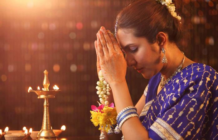 Woman praying in pooja room