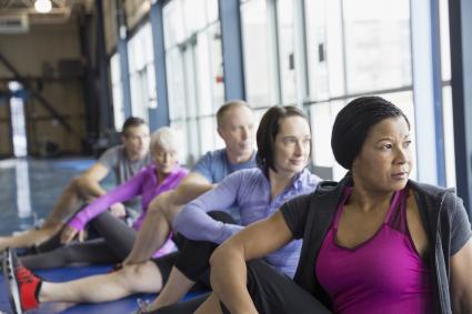 People stretching their hips in exercise class