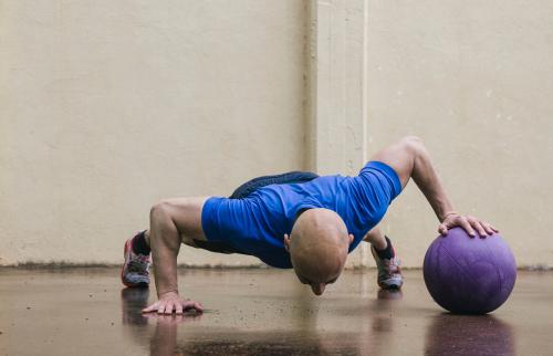 Man doing push-ups with a medicine ball