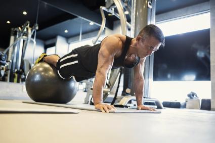 Mature adult man working out at Personal training gym