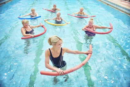 A group of senior ladies take part in a water aerobics session