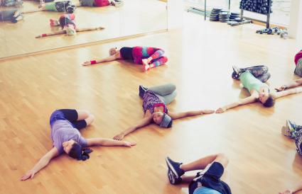 Exercise class doing twisted stretch in studio