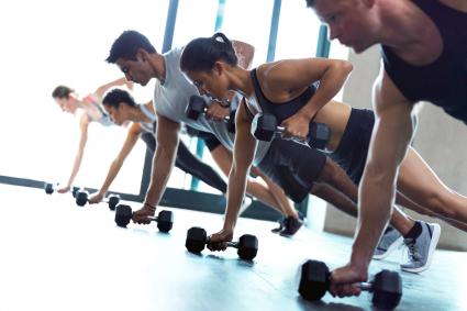 Fitness group working out with dumbbells in a gym