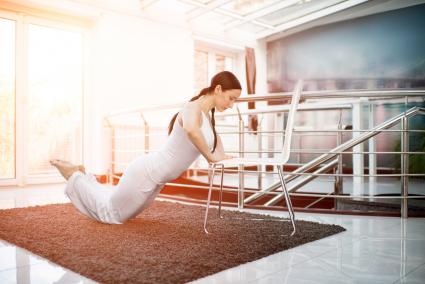 Woman doing chair push-ups at home