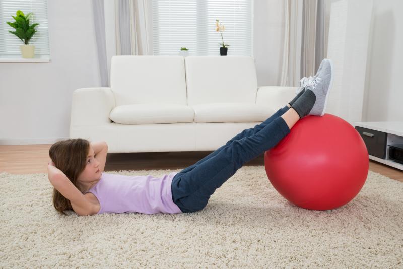 girl doing crunches with a yoga ball