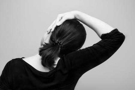 Rear view of woman stretching neck