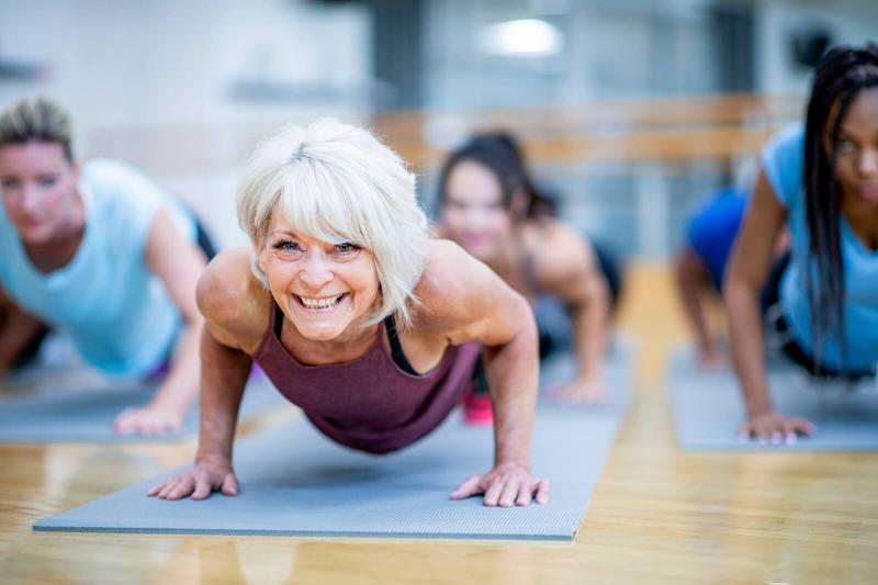 Woman in Fitness Class in a Plank Pose Smiling
