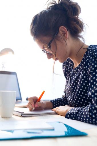 Woman writing in her home office