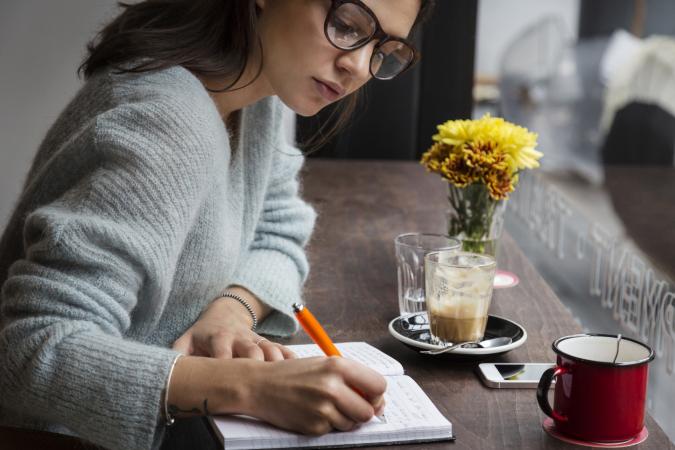 Woman at window writing notes