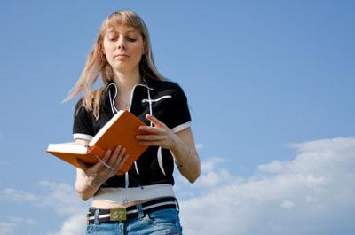 Woman reading a book before writing a review