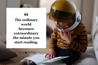 Boy wearing a cosmonaut helmet and reading a book at home